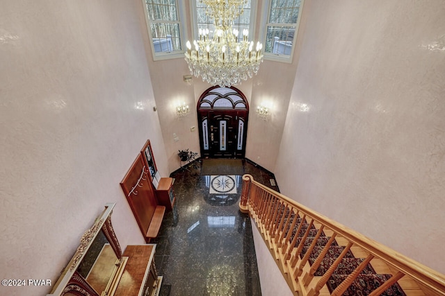 entrance foyer with a towering ceiling and an inviting chandelier