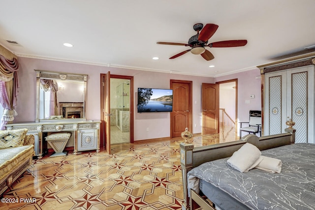 bedroom featuring ensuite bath, ceiling fan, crown molding, and a fireplace