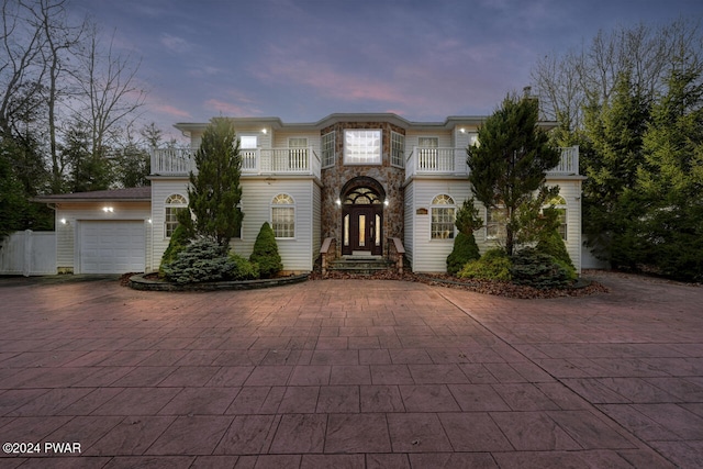 view of front of property featuring a balcony, french doors, and a garage