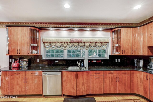 kitchen featuring tasteful backsplash, dark stone countertops, sink, and stainless steel dishwasher