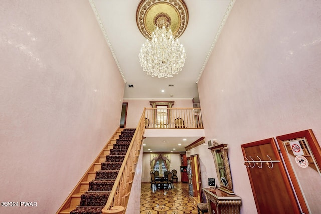 stairway featuring a high ceiling and a notable chandelier