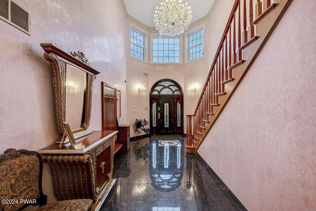 foyer entrance with a chandelier and a high ceiling