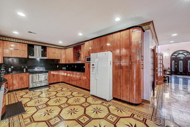 kitchen with stainless steel appliances, tasteful backsplash, and wall chimney exhaust hood