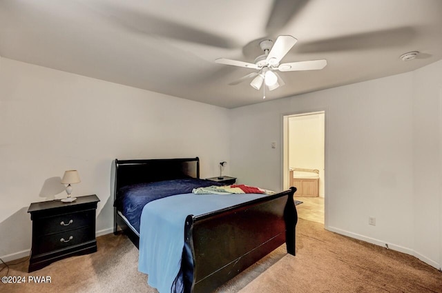 carpeted bedroom with ensuite bath and ceiling fan