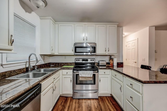 kitchen featuring white cabinets, appliances with stainless steel finishes, kitchen peninsula, and sink