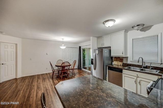 kitchen with stainless steel appliances, dark wood-type flooring, sink, decorative light fixtures, and white cabinets