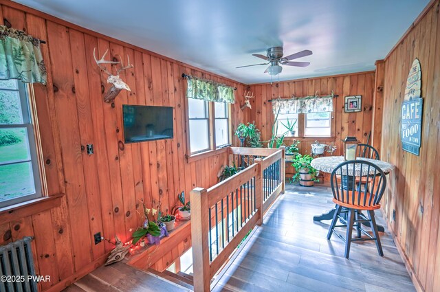 162 Plank Rd, Beach Lake, PA 18405 - dining space featuring radiator heating unit, wood finished floors, wood walls, and a ceiling fan