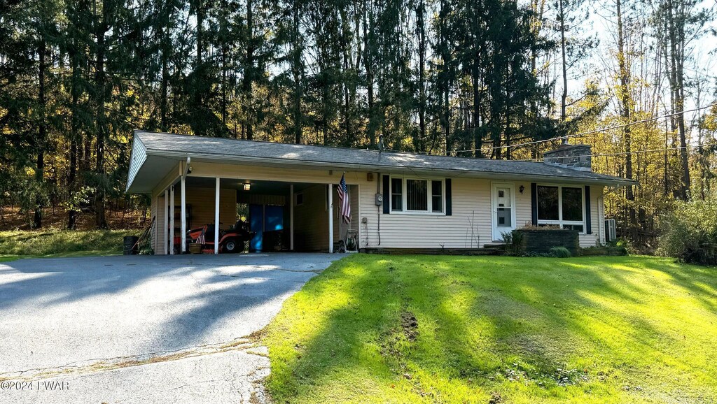 ranch-style house with a front lawn and a carport