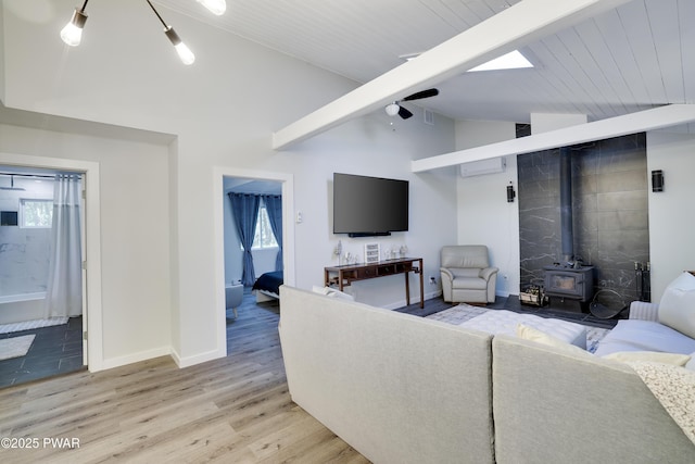 439 Gold Finch Rd, Bushkill, PA 18324 - living room with a wood stove, light wood-style floors, a ceiling fan, baseboards, and a wall mounted AC