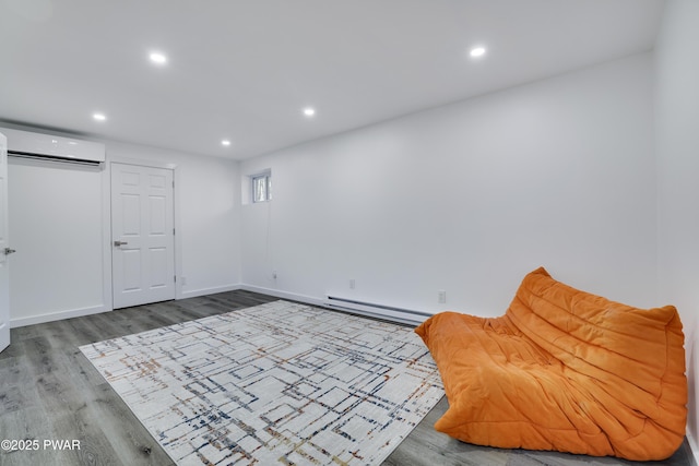 439 Gold Finch Rd, Bushkill, PA 18324 - unfurnished room with a baseboard heating unit, an AC wall unit, recessed lighting, wood finished floors, and baseboards