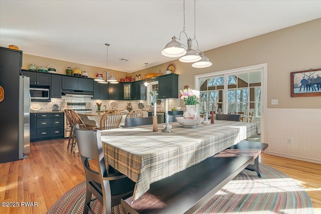 dining room with visible vents, a wainscoted wall, and light wood finished floors