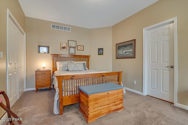 bedroom with baseboards, visible vents, a closet, and light carpet