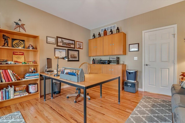 office space with baseboards and light wood-type flooring