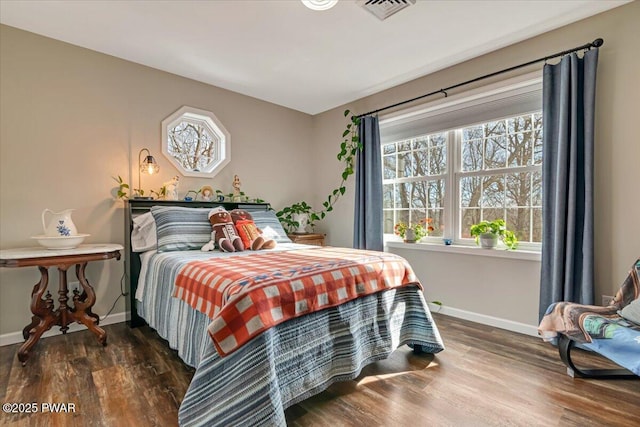 bedroom featuring visible vents, wood finished floors, and baseboards