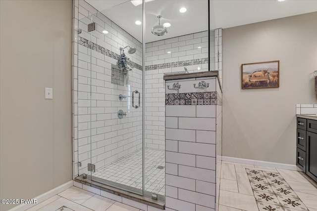 bathroom with vanity, baseboards, and a stall shower