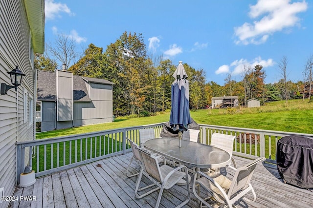 wooden deck featuring a lawn and area for grilling