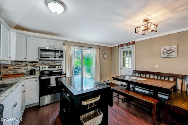 kitchen with white cabinets, appliances with stainless steel finishes, tasteful backsplash, and light stone counters