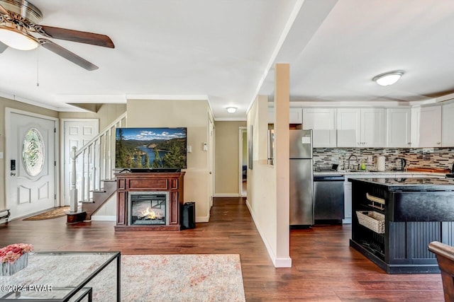 kitchen with ceiling fan, sink, stainless steel appliances, backsplash, and white cabinets