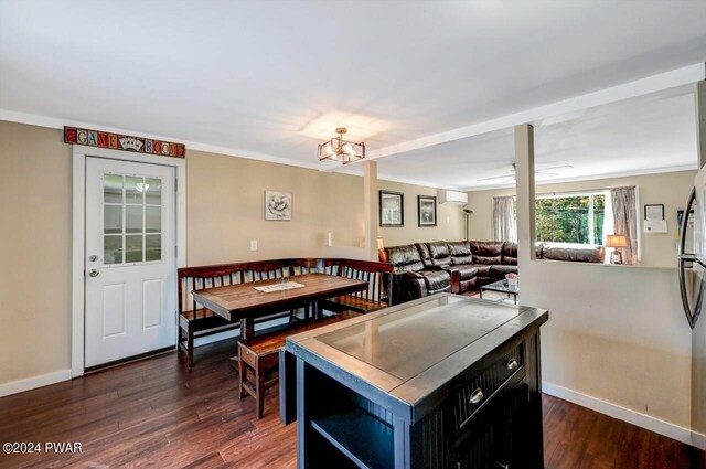 kitchen featuring a notable chandelier, a center island, crown molding, and dark wood-type flooring