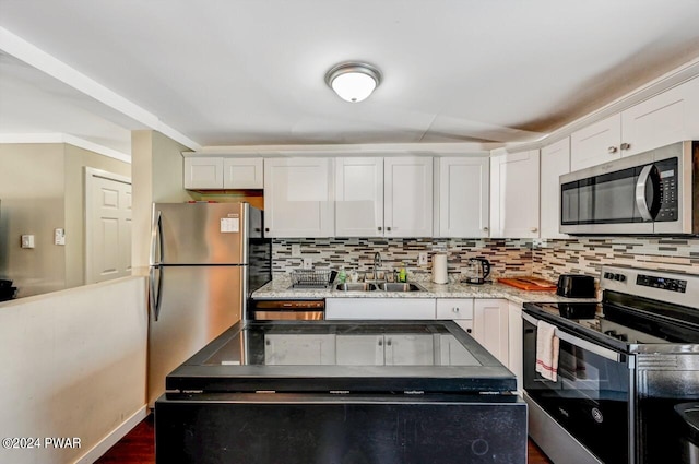 kitchen with dark hardwood / wood-style flooring, tasteful backsplash, stainless steel appliances, sink, and white cabinets