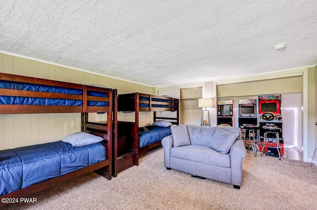 carpeted bedroom featuring a textured ceiling and wood walls