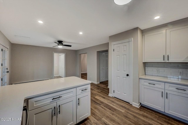 kitchen featuring ceiling fan, decorative backsplash, dark wood-type flooring, and white cabinets