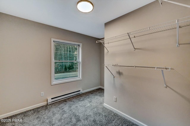 spacious closet with a baseboard heating unit and carpet flooring