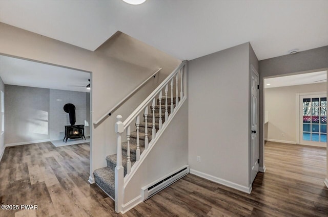 stairs featuring a baseboard heating unit and wood-type flooring