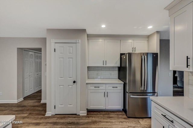 kitchen with white cabinetry, dark wood-type flooring, and stainless steel refrigerator