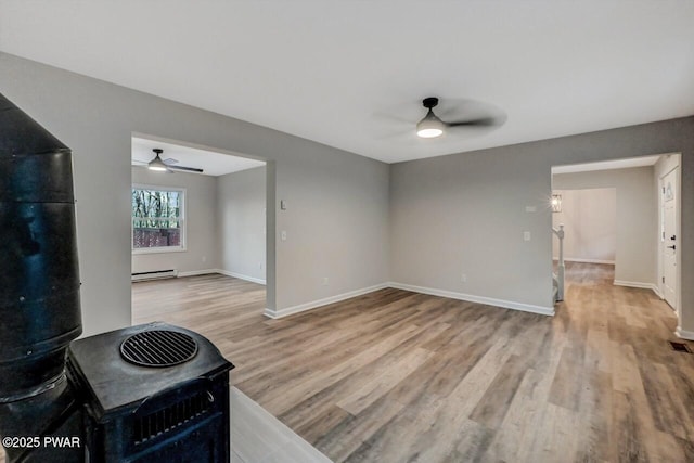 interior space with ceiling fan, a baseboard radiator, and light hardwood / wood-style flooring