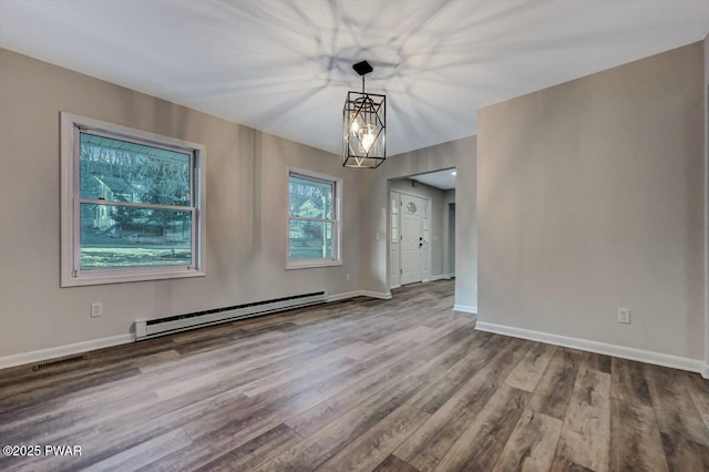 interior space with wood-type flooring and a baseboard heating unit