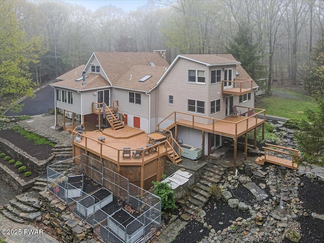 142 Bloss Rd, Canadensis, PA 18325 - back of house with stairs, a hot tub, a wooded view, and a shingled roof
