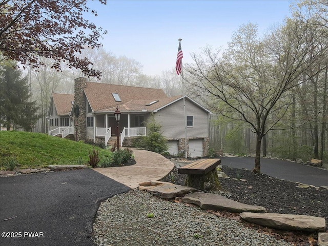 142 Bloss Rd, Canadensis, PA 18325 - view of front of home featuring asphalt driveway, an attached garage, covered porch, and a chimney