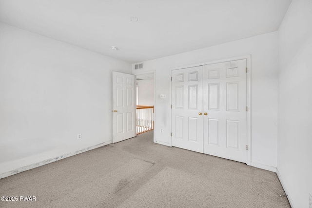 unfurnished bedroom with a closet, baseboards, visible vents, and carpet floors