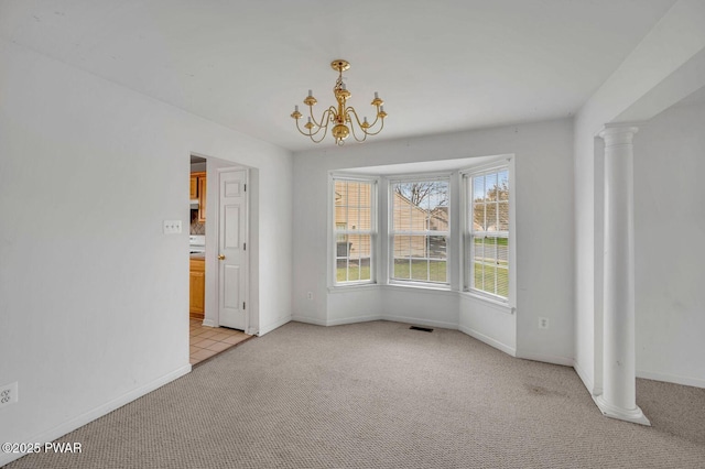 unfurnished dining area featuring decorative columns, an inviting chandelier, light colored carpet, visible vents, and baseboards