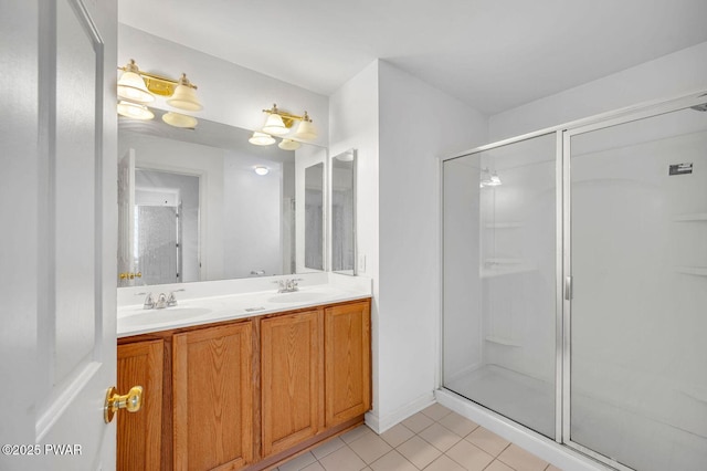full bath with a shower stall, tile patterned floors, double vanity, and a sink