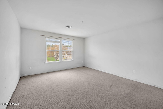 carpeted empty room with visible vents and baseboards