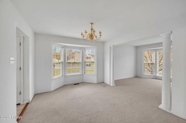 spare room featuring baseboards, carpet flooring, a notable chandelier, and plenty of natural light
