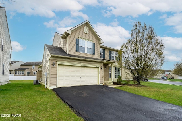traditional-style home with central air condition unit, driveway, a front yard, a garage, and fence