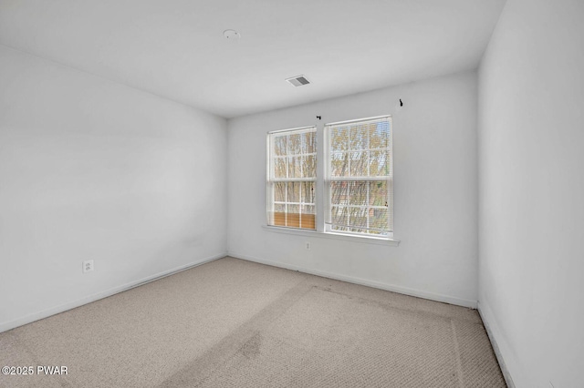 spare room featuring baseboards, visible vents, and carpet floors