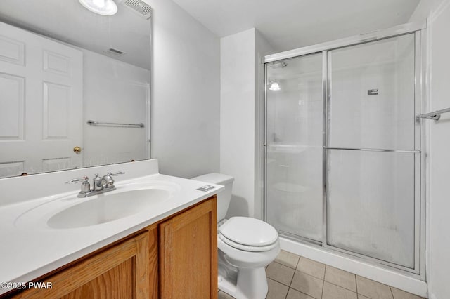 bathroom with visible vents, toilet, vanity, tile patterned floors, and a stall shower