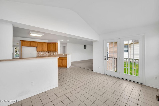 unfurnished living room featuring light tile patterned floors and vaulted ceiling