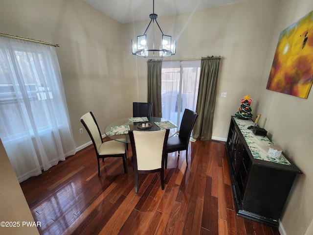 dining space with dark hardwood / wood-style floors and an inviting chandelier