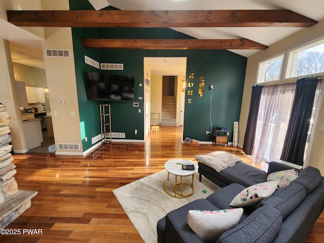 living room with hardwood / wood-style floors and vaulted ceiling with beams