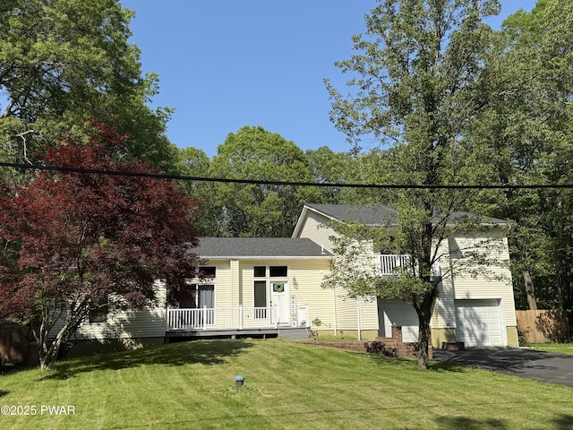 12044 Maplewood Dr, East Stroudsburg, PA 18302 - view of property hidden behind natural elements with asphalt driveway, a garage, and a front yard