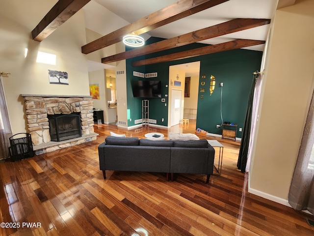 living room featuring lofted ceiling with beams, a fireplace, and wood-type flooring