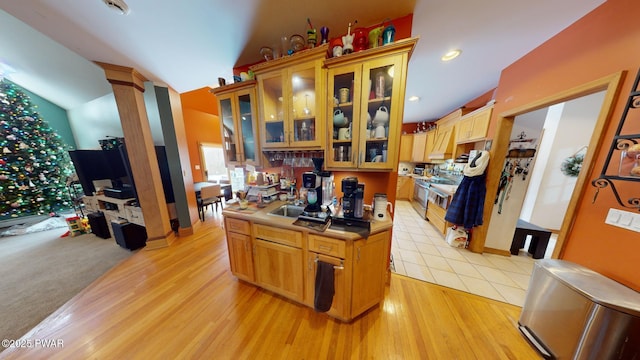 kitchen with electric stove, light hardwood / wood-style flooring, and decorative columns