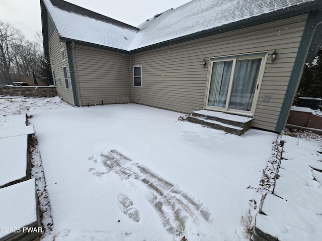 view of snow covered rear of property