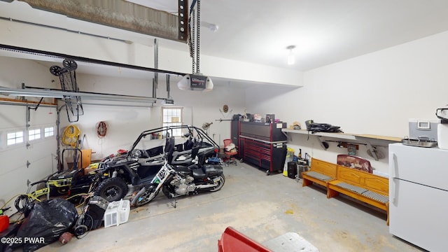 garage featuring white fridge and a garage door opener