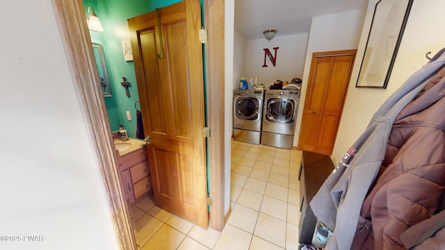 laundry room with washer and dryer and light tile patterned flooring